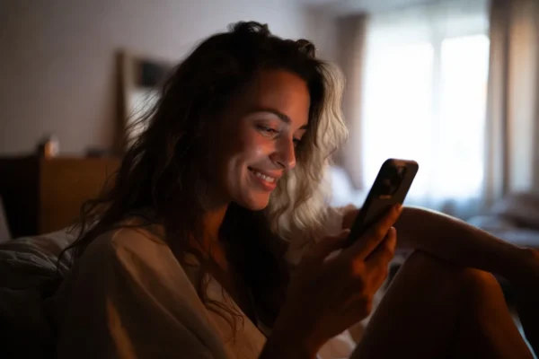 Woman chatting anonymously on her phone during a relaxing evening at home