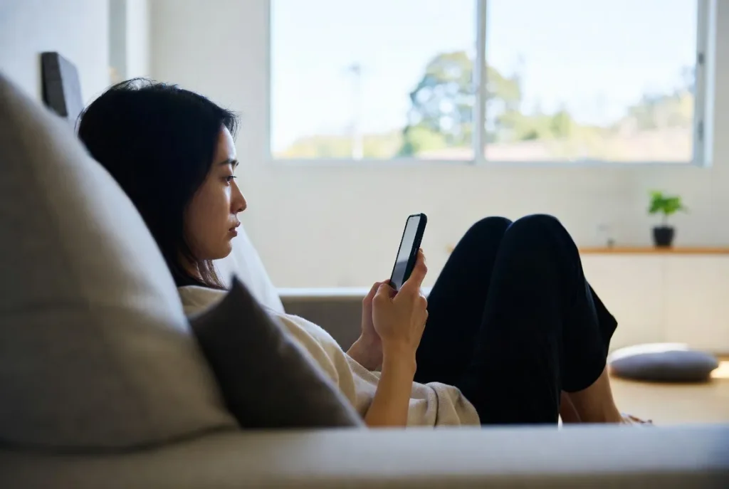 Woman relaxing at home while using a japanese chat app