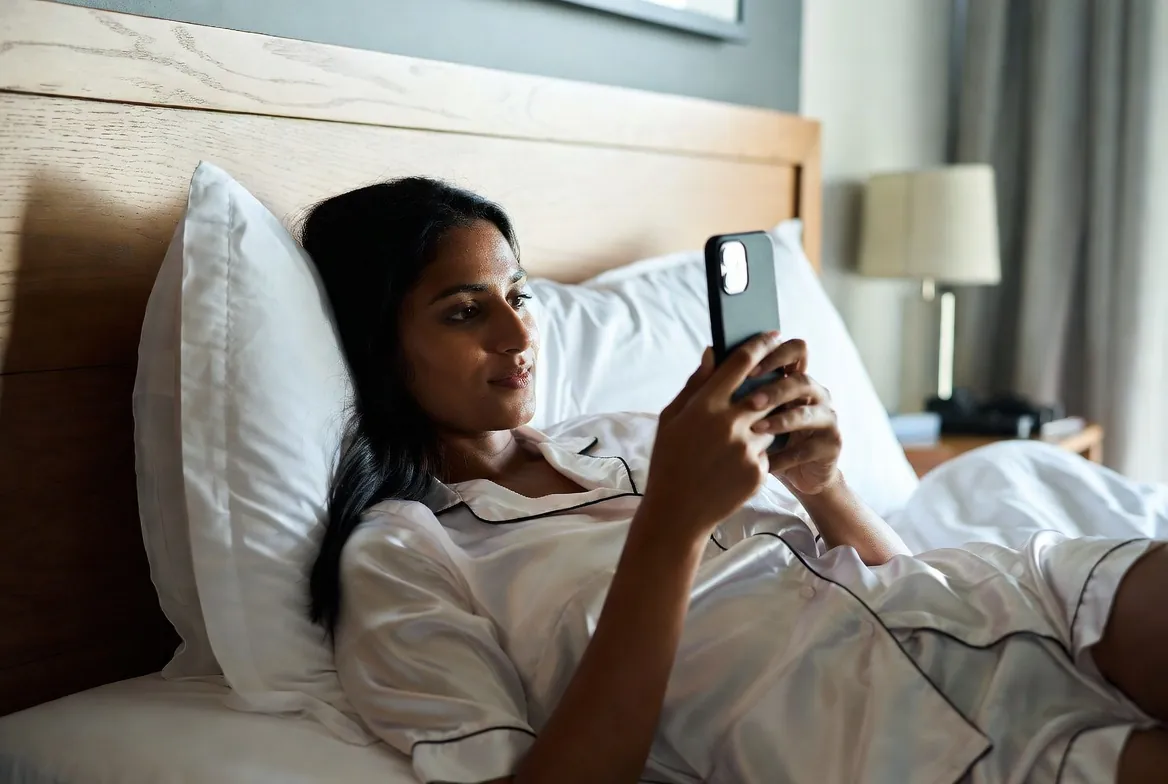 Woman relaxing in bed with a tamil chat conversation