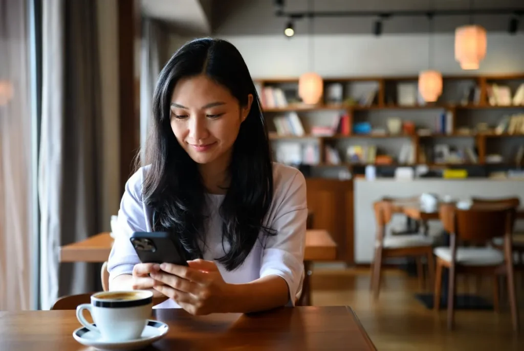 Woman using japanese chat while relaxing in a cozy cafe
