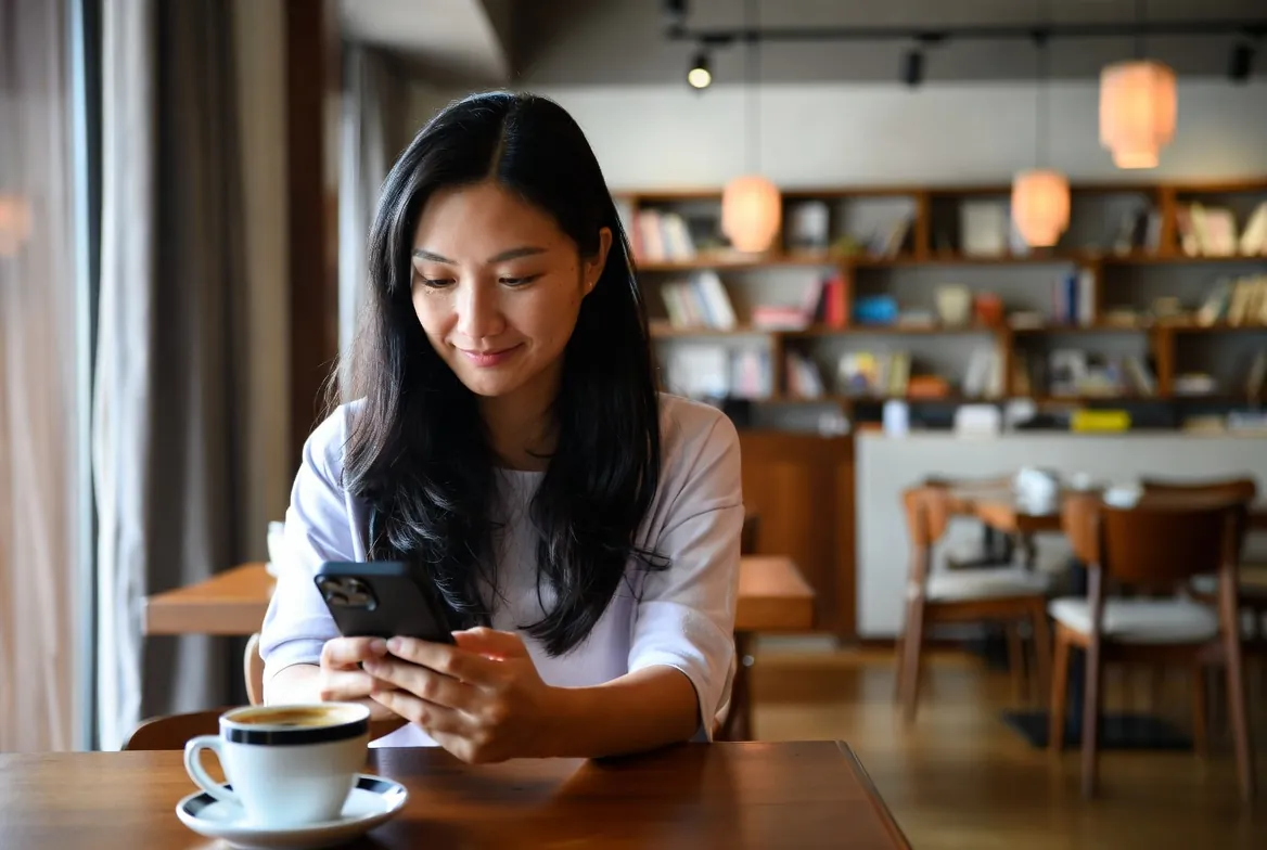 Woman using japanese chat while relaxing in a cozy cafe